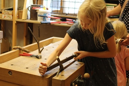 Mädchen fertigt Garderobenhaken aus Naturholz